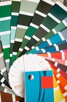 val av färgfärg för dekorativa hemreparationer på paletten med layouter. ett fan av nyanser i handen inne i hemmet. reparation och konstruktion, färg och lackbeläggning foto