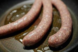 närbild av tysk bratwurst i en panna foto