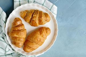 nybakade croissanter på svart tallrik. franska och amerikanska croissanter och bakade bakverk avnjuts över hela världen. foto