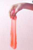 barn hand som håller rosa färg slime foto