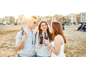 vänner dricker öl på stranden foto