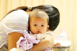 asiatisk baby på sjukhus med mamma. sjukt barn med mamma på sjukhus foto