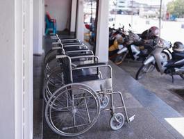 närbild rad av tomma rullstolar parkering utanför förberedd för äldre och funktionshindrade passagerare foto