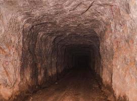 inuti gammal djup tunnel för tennbrytning. bergväggsgrotta med stenig väg. resor plats i string pha phum, kanchanaburi, thailand kallas 3d tunnel. foto