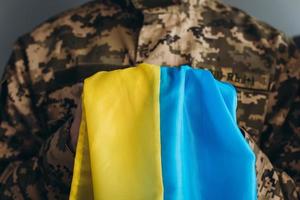 ukrainsk patriotsoldat i militäruniform med en gul och blå flagga på kontoret foto