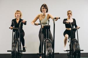 ung man och kvinnor som använder air bike för konditionsträning på crosstraining gym foto