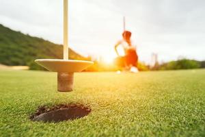 golfboll på grönt gräs redo att slås på golfklubben, närbild på golfbanor i thailand foto