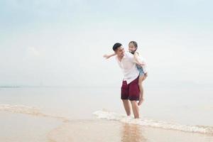 lycklig familj på stranden springa och hoppa i solnedgången foto