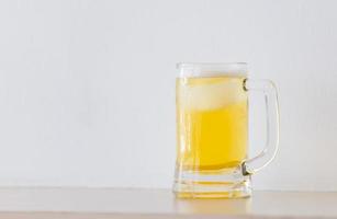 glas öl på disk, mugg med öl på bord vit bakgrund foto