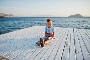 pojke sitta på turkey resort på piren mot Medelhavet. foto