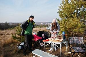 familjen grillar på ett däck i tallskogen. laga mat utomhus. foto