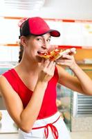 kvinna äter en bit pizza foto