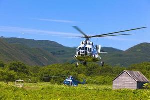 vulkan och helikopter i kamchatka foto