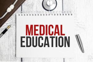 texten medicinsk utbildning på en anteckningsbok på ett vitt bord bredvid ett stetoskop foto