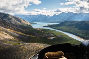 Flygfoto från helikopter av klippiga berg med turkos sjö och blå himmel i banff nationalpark foto