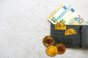 ovanifrån av gyllene bitcoin-mynt i en plånbok med eurosedlar. elektronisk kryptovaluta foto