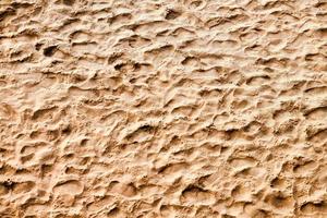 fotspår på sand, ovanifrån av havet strand bakgrund, gyllene sand foto