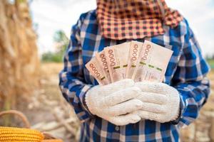 majsbönder håller thailändska sedlar värda 5 000 baht som folk får från regeringen. foto