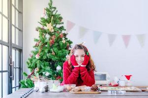 Europeiska flickor förbereder verktyg och ingredienser för att göra pepparkakor under jul- och nyårsfirandet foto