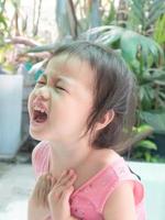 porträtt av upprörd stress ledsen olycklig asiatisk gråtande liten toddler girl i en ålder av fruktansvärda två. foto