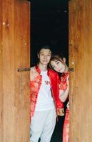lyckliga unga asiatiska par i traditionella kinesiska klänningar foto