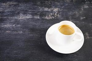 kopp kaffe espresso. varm dryck kaffe på mörk bakgrund foto