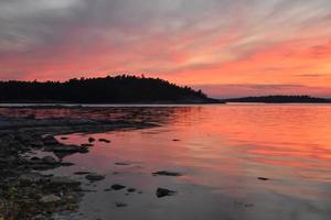 röd romantisk solnedgång över en sjö i sverige foto