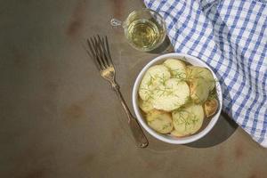 hälsosam mat potatissallad i skål på brun bordsskiva kopia utrymme. foto