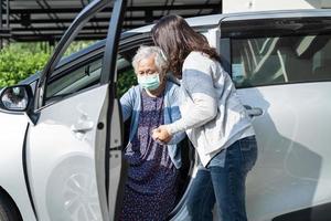 hjälp och stöd asiatisk senior eller äldre gammal dam kvinna patientpromenad med rullator förbereda sig för att komma till sin bil, hälsosamt starkt medicinskt koncept. foto