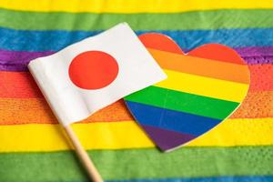 Japans flagga på regnbågsbakgrund symbol för hbt gay pride månad social rörelse regnbågsflagga är en symbol för lesbiska, homosexuella, bisexuella, transpersoner, mänskliga rättigheter, tolerans och fred. foto