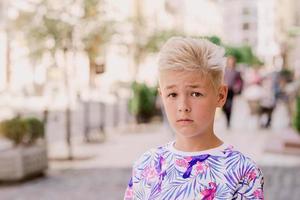 porträtt av söt stilig blond elva gammal pojke förlorad i staden. växa upp, barndom, separera koncept foto