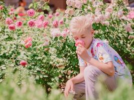 kaukasisk pojke som luktar blomma foto