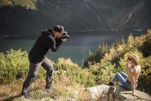 vacker kvinna ler till sin pojkväns kamera medan de reser foto