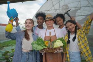 en ung mångsidig grupp som har roligt och njuter av känslor i plantage organic's farm växthus. foto