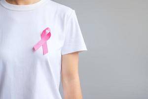 oktober månad för medvetenhet om bröstcancer, äldre kvinna i vit t-shirt med rosa band för att stödja människor som lever och sjukdomar. internationella kvinnor, mor och världen cancer dag koncept foto
