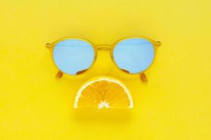 skiva orange frukt set som ledsen mun och gula solglasögon. foto