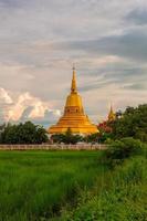 gyllene pagod framför gröna risfält foto