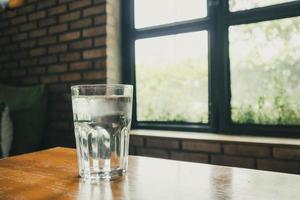 glas mineralvatten på träbord i restaurangen foto