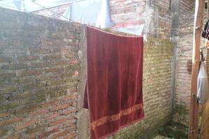ett foto av den mörkröda handduken att torka i solen