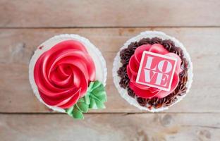 röd ros cupcakes på träbord foto