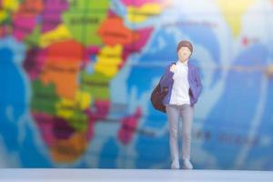 miniatyr människor resenär med ryggsäck på globen bakgrund foto