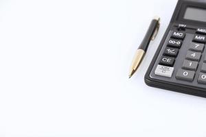 svart färg kalkylator och gul-svart metall penna på en vit bakgrund finansiell aktivitet, redovisning, skatteberäkning eller sparande och investeringar. kopieringsutrymme. foto