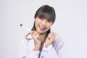 ung kvinnlig tandläkare leende över vit bakgrund studio foto