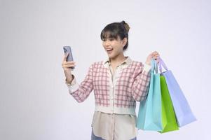 attraktiv shopper kvinna med shoppingkassar över vit bakgrund foto