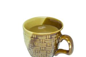 kaffe i en ljusbrun keramisk mugg på vit bakgrund - bakgrundsreflektioner. koffeinhaltigt kaffe är populärt bland människor över hela världen att konsumera. foto
