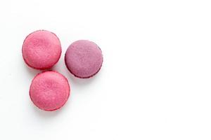 ljusa macaroons på vit bakgrund. söt mat tapet med plats för text. foto