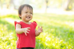 porträtt ansikte av söt asiatisk liten flicka och barn lycka och kul i parken på sommaren, le och glad från asien barn och koppla av i trädgården, livsstil barndom koncept. foto