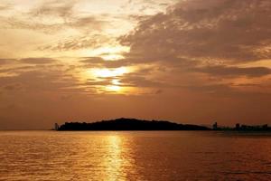 soluppgång med moln och hav och himmel på morgonen, solnedgångssilhuett med havet på sommaren, dramatisk bukt eller kustlandskap vackert, natur havsbildskoncept. foto