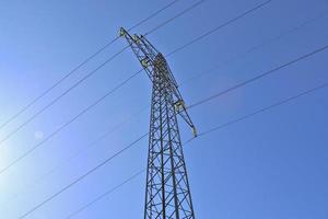 närbild på en stor makt pylon som transporterar el i ett landsbygdsområde foto