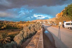 bostadshus med väg mot dramatisk himmel i solig sommardag foto